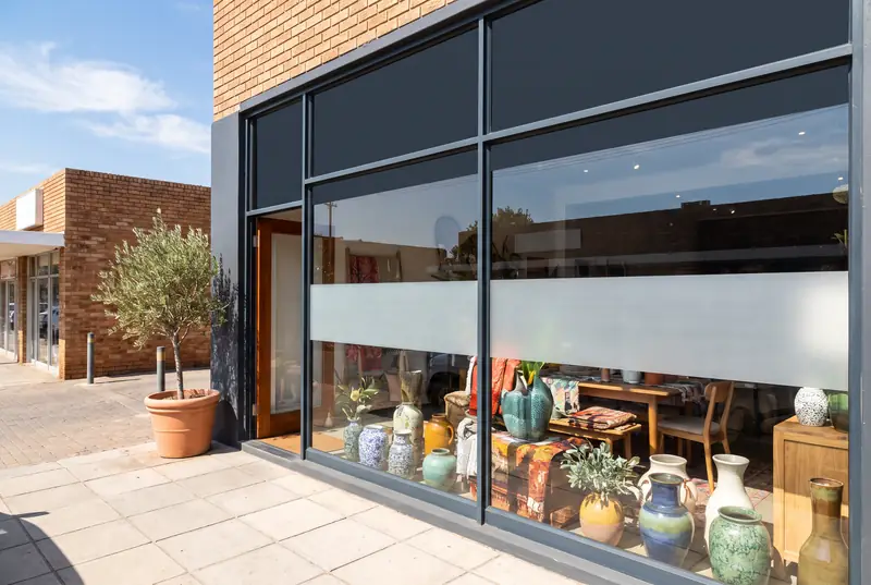 A shopfront with window tint and a frosted band.